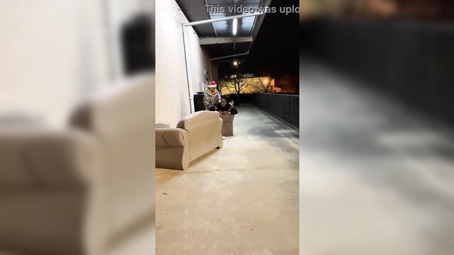 Clown girl in sexy Santa hat sits by trash on balcony in The Clown Who Stole Christmas