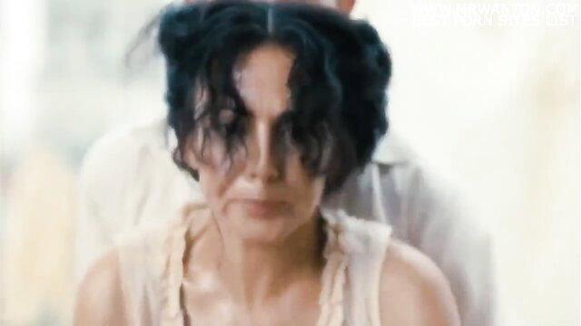 Brunette with intense expression in sheer top, closeup face and cleavage