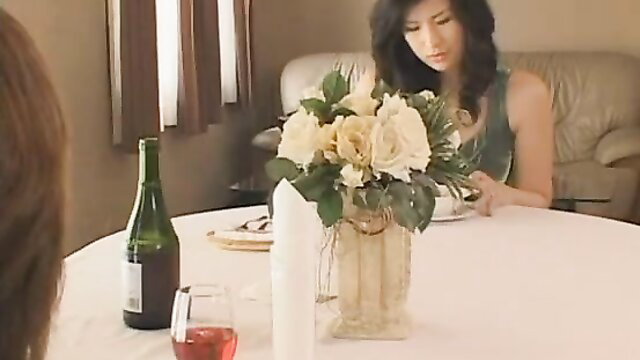 Hot Asian woman in green dress at romantic table with wine and roses