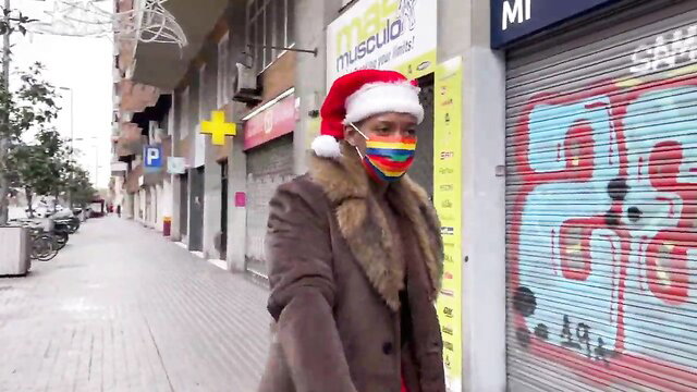 Medusa in fur coat, rainbow mask & Santa hat on urban street