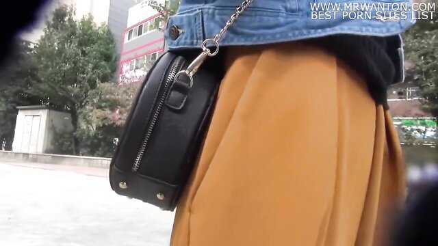 Cute short-haired Japanese college girl in orange skirt and denim jacket, upskirt view