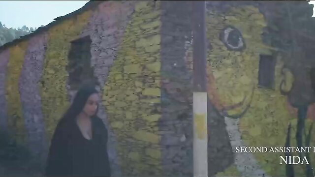 Indian beauty Nehal in Maya ep.1 stands by vibrant wall, dark hair flowing