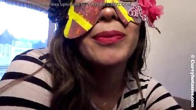 Curvy Latina with big lips smiling in funky glasses and headband