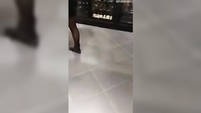 Sexy Asian woman in stockings and heels walking in supermarket