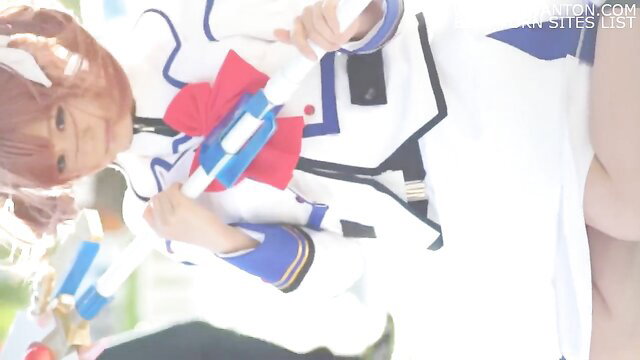 Cute cosplay girl in sailor uniform bends over flashing panties at photoshoot