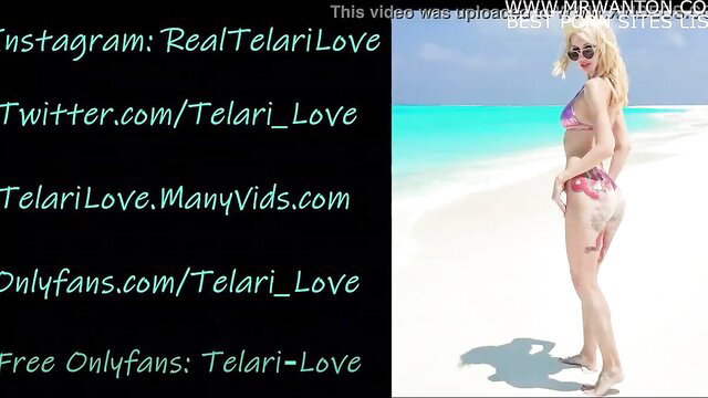 Blonde bombshell Telari Love in pink bikini on beach, sexy pose