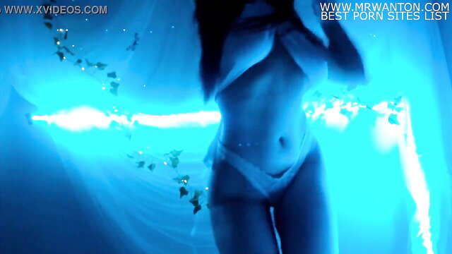 Stunning black babe in skimpy white bikini dances topless in neon blue lights