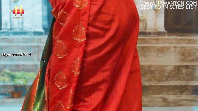 Indian aunty in red sari showing curves, opens blouse tease