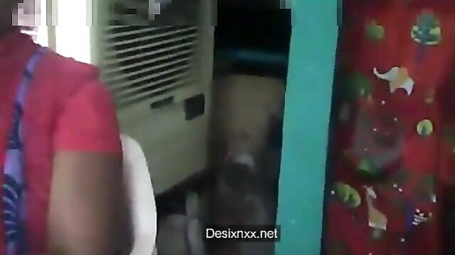 Indian aunty in red saree by AC unit in home, mature desi tease