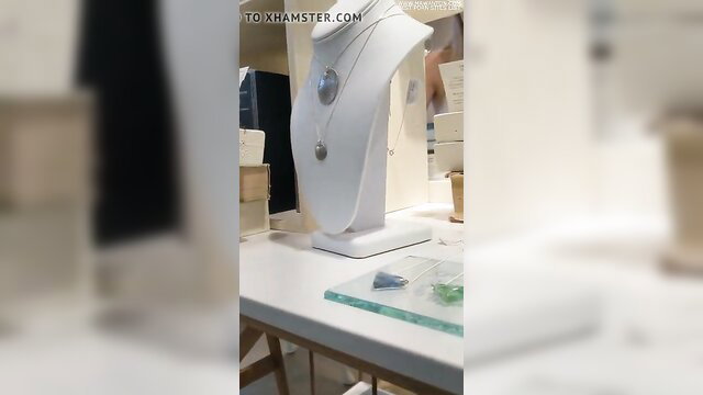 Jewelry display with necklace on white bust in store, tight blonde lesbian tease