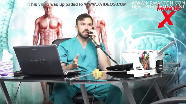 Hot male doctor in scrubs on phone at desk in nutritionist office