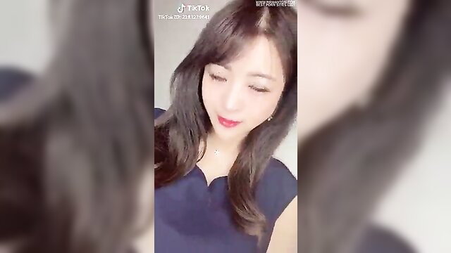 Japanese TikTok girl with bangs smiling in tight navy dress