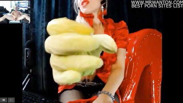 Redhead in red dress holds giant yellow dildo, dirty talk closeup