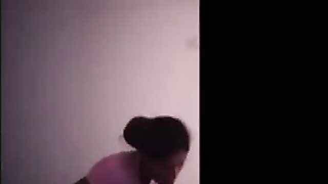 Black woman with bun in pink top at massage parlor