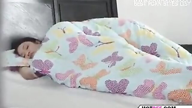 Asian teen girl sleeping under colorful butterfly blanket