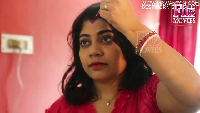 Indian aunty with big boobs in red dress applying bindi closeup