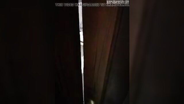 Wife bent over dark room with friends watching through curtains