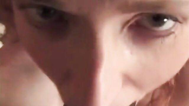 Closeup of redhead woman's intense eyes and face screaming in ecstasy