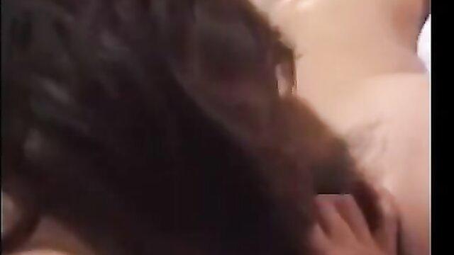 Blurry closeup of brunette with beard licking pale woman's tattooed neck