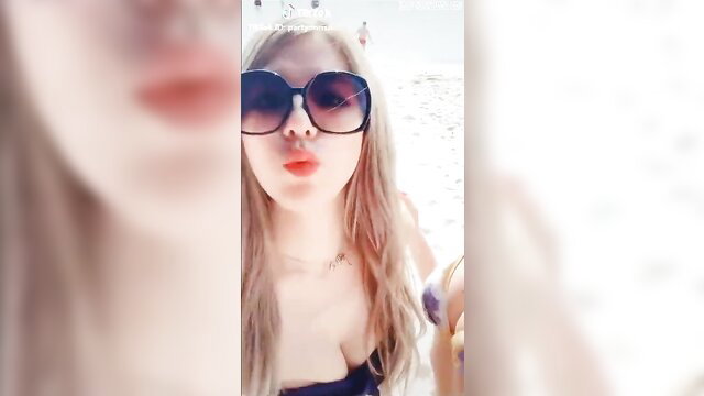 Blonde Asian TikTok girl in bikini top pouting sexy beach pose