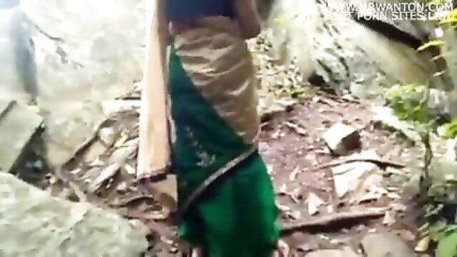 Beautiful Indian village aunty in green saree on outdoor rocky trail