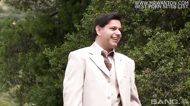 Bonny in white suit smiling outdoors, elegant tease