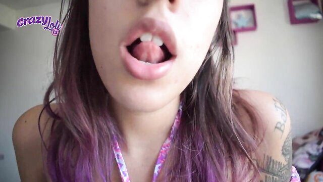 Purple-haired tattooed girl moans, shows long wet tongue closeup