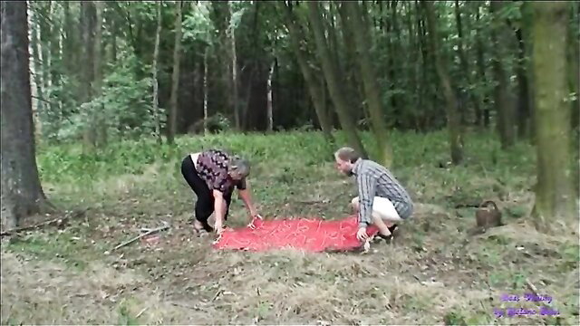 Elderly couple squats nude over red cloth in forest, old man and big tits mature