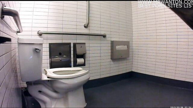 Chipotle public toilet interior with white tiles and grab bars