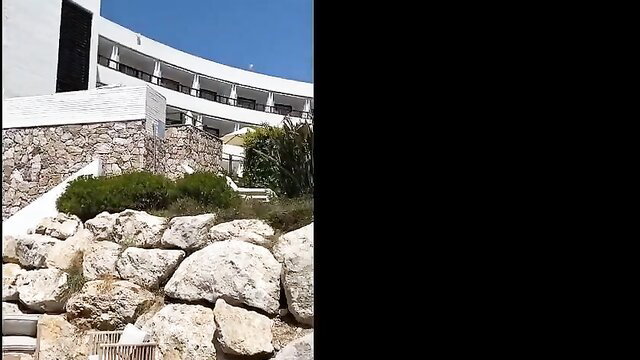 Elysa Exhib at white curved hotel in Spain, rocky garden view