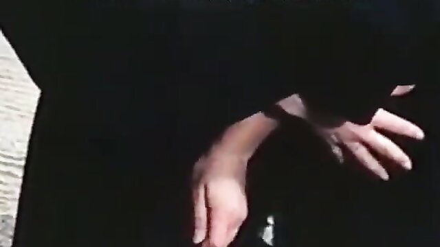 Nympho Nuns: mysterious woman in habit kneels with hands on wooden surface