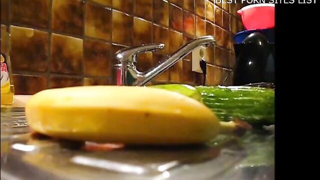 Hot amateur babe teases with wet banana and cucumber in kitchen