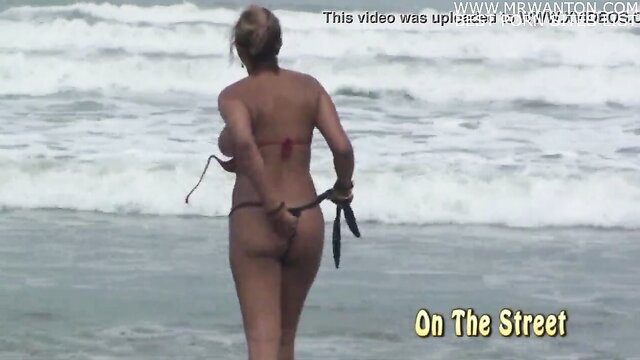 Blonde Brazilian beach babe in thong bikini walking away, big ass view