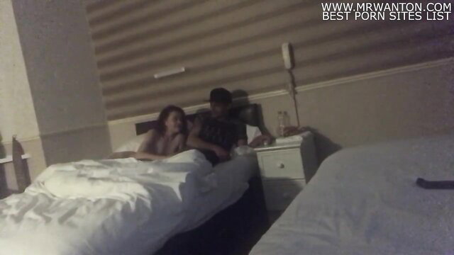 Laura giving blowjob to man in hotel room bed