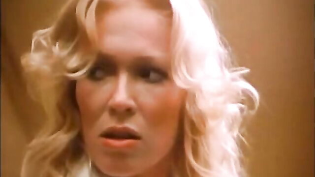 Blonde bombshell with big tits in open blouse, seductive 1978 porn thumbnail