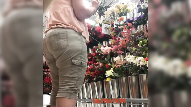 Horny granny in tight khaki shorts bending over flower display