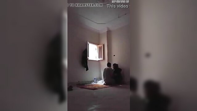 Arab couple in prayer room, man and woman kneeling on rug