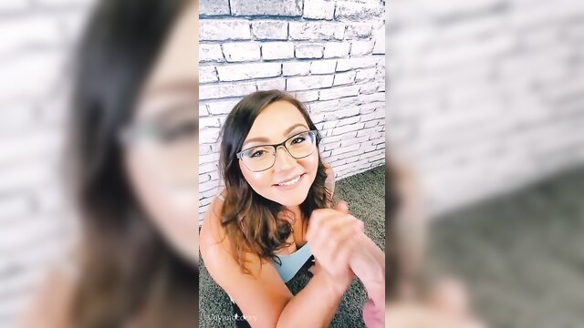 Coy Wilder smiling with new glasses on white brick wall