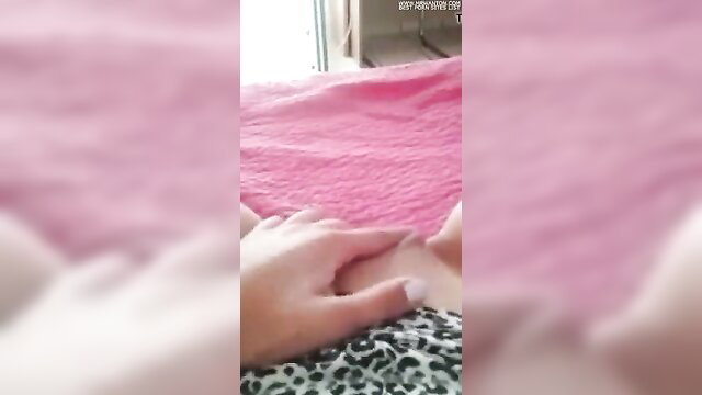Asian woman holding hands intimately on pink bed, open window view