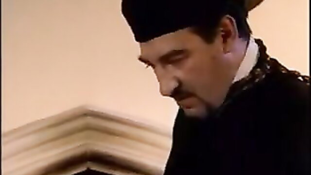 Priest in traditional robes with mustache and taqiyah hat closeup