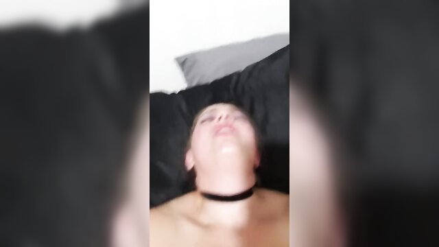 Amateur solo woman lying nude on bed with choker collar, at home alone