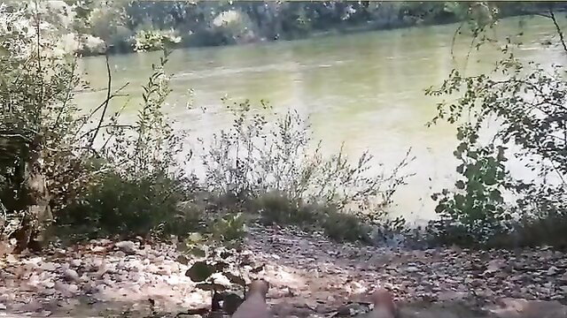 Woman sitting on a rocky riverbank