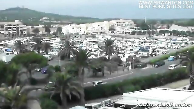 Aerial view of crowded Middle Eastern beach parking lot with cars and palms