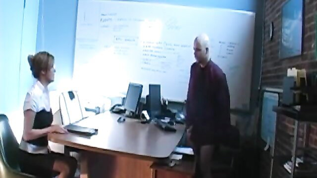 Sexy blonde secretary in white blouse and short skirt at office desk