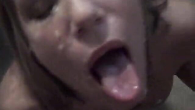 Closeup of woman with open mouth sticking tongue out, sweaty face