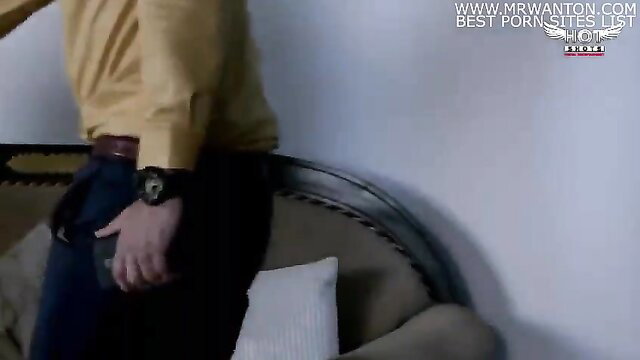 Indian man in yellow shirt and jeans stands by couch in sexy interview tease