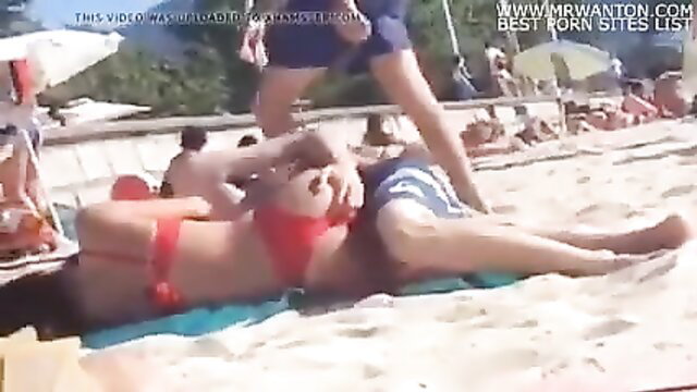 Teen in red bikini fingered by guy on crowded beach
