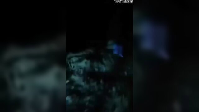 Blurry closeup of nude woman with blue dildo insertion in dim light