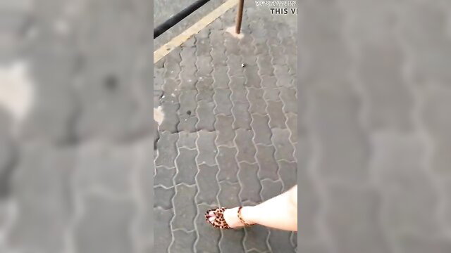 Sexy white legs in leopard heels walking on pavement, denim mini skirt tease