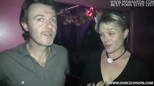 Mature blonde and man chatting intimately in libertine club